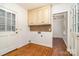 Bright laundry room with wooden floor, storage cabinets, and washer-dryer hookups at 1209 Alfred St, Charlotte, NC 28211