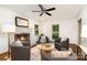 Bright living room offers a ceiling fan, hardwood floors, fireplace, and large windows for natural light at 1209 Alfred St, Charlotte, NC 28211