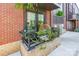 Charming outdoor balcony features plants, a cozy chair, and is surrounded by brick at 130 Rail Crossing Ln # 101, Charlotte, NC 28209