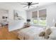 Bright bedroom features a beach-themed art piece, ceiling fan, and cozy white bedding at 130 Rail Crossing Ln # 101, Charlotte, NC 28209