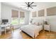 The bedroom includes a workspace, a cozy bed, and lots of light from the windows at 130 Rail Crossing Ln # 101, Charlotte, NC 28209