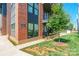 Close up of red brick condominium with gray accents, greenery, and an outdoor balcony at 130 Rail Crossing Ln # 101, Charlotte, NC 28209