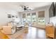 Bright living room features hardwood floors, modern furnishings, and large windows with neutral roman shades at 130 Rail Crossing Ln # 101, Charlotte, NC 28209