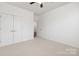 Bright, spacious bedroom with neutral carpet, a ceiling fan, and a double door closet, creating a serene living space at 14210 Asbury Park Rd, Huntersville, NC 28078