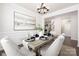 Chic dining room featuring a modern chandelier, wainscoting detail, and a stylish table setting, creating an inviting atmosphere at 14210 Asbury Park Rd, Huntersville, NC 28078