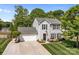 Aerial view of a two-story home featuring landscaped yard, attached garage, and tree lined backyard at 150 Pleasant Grove Ln, Mooresville, NC 28115