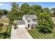 An aerial view of a two-story home with a driveway, manicured lawn, and tree lined backyard at 150 Pleasant Grove Ln, Mooresville, NC 28115