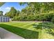Lush backyard with privacy bushes and shed, with the view from the patio at 150 Pleasant Grove Ln, Mooresville, NC 28115