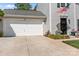 Exterior view featuring a driveway with a white garage door, flowerbeds, and siding at 150 Pleasant Grove Ln, Mooresville, NC 28115