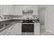 Close up of kitchen range with white cabinets, granite countertops, and subway tile backsplash at 150 Pleasant Grove Ln, Mooresville, NC 28115