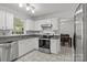 Bright kitchen with stainless steel appliances, gray countertops, white cabinets, and tiled flooring at 150 Pleasant Grove Ln, Mooresville, NC 28115