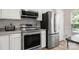 Stainless steel appliances including a refrigerator, oven, and microwave, complement white cabinets and granite countertops at 15746 Marvin Rd, Charlotte, NC 28277