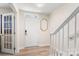 Bright foyer with white front door, hardwood floors, staircase, and glass french doors at 15746 Marvin Rd, Charlotte, NC 28277