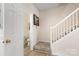 Inviting hallway with wood floors, stairs, and a peek into the half bathroom at 15746 Marvin Rd, Charlotte, NC 28277