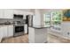 Modern kitchen with stainless steel appliances, an island with granite countertop and white cabinets, complemented by natural light at 15746 Marvin Rd, Charlotte, NC 28277
