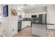 Well-lit kitchen featuring stainless steel appliances, a granite island, and white cabinetry, creating a clean and modern space at 15746 Marvin Rd, Charlotte, NC 28277