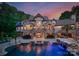 Expansive backyard with a sparkling pool, stone accents, lush landscaping, and elegant exterior at 172 Tennessee Cir, Mooresville, NC 28117