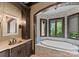 Bathroom with stone surround bathtub and a vanity with copper sink, offering a tranquil and spa-like retreat at 172 Tennessee Cir, Mooresville, NC 28117