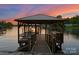 Picturesque waterfront dock with covered seating area, providing stunning views of the calm lake at 172 Tennessee Cir, Mooresville, NC 28117