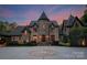 Elegant stone home with tower, inviting entryway, and manicured landscaping at 172 Tennessee Cir, Mooresville, NC 28117