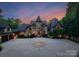 Majestic castle-like home with stone facade, turret, circular drive, and beautifully landscaped grounds at 172 Tennessee Cir, Mooresville, NC 28117