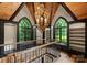 A naturally lit hallway with dark wood trim, a custom railing, and views of the surrounding trees at 172 Tennessee Cir, Mooresville, NC 28117