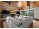 Cozy living room with a stone fireplace, wood beams, and a comfortable sectional sofa with lake views at 172 Tennessee Cir, Mooresville, NC 28117