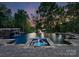 Luxurious pool with waterfall feature, integrated spa, and stone surround, surrounded by mature trees at 172 Tennessee Cir, Mooresville, NC 28117