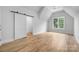 Bedroom featuring a sliding door closet, hardwood floors, white walls, ceiling fan, and window at 1817 Union St, Charlotte, NC 28205