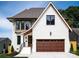 Charming two-story home features a white brick facade, dark trim windows and a spacious two-car garage at 1817 Union St, Charlotte, NC 28205