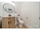 Well-lit half bath with a modern vanity and a round mirror, offering a fresh and clean look at 2003 Briarwood Cir, Fort Mill, SC 29715