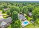 Aerial view showcases a house with a pool, deck, and lush greenery at 208 Wellington Dr, Lincolnton, NC 28092