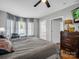 Spacious bedroom features a large bed, wood floors, and sun-filled windows with curtains at 208 Wellington Dr, Lincolnton, NC 28092