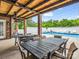 View of covered patio with outdoor tables next to an in-ground pool and backyard at 208 Wellington Dr, Lincolnton, NC 28092
