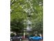 A modern building exterior with large windows and well maintained landscaping and cars parked out front at 2116 Mcclintock Rd # 123, Charlotte, NC 28205