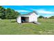 Outbuilding with a roll up door and ramp on a well-maintained lawn at 221 Abner Rd, Stony Point, NC 28678