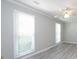 Bright bedroom with two windows, ceiling fan, and light gray wood-look floors at 2502 Breuster Dr, Charlotte, NC 28210