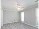 Bright bedroom with two windows, ceiling fan, and light gray wood-look floors at 2502 Breuster Dr, Charlotte, NC 28210
