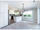 Bright dining area featuring an elegant chandelier, white cabinets, and abundant natural light at 2502 Breuster Dr, Charlotte, NC 28210