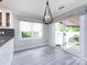 Bright dining area featuring a modern chandelier, sliding glass doors, and sleek gray floors at 2502 Breuster Dr, Charlotte, NC 28210