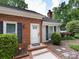 Brick home featuring front door with decorative shutters and well-maintained landscaping at 2502 Breuster Dr, Charlotte, NC 28210