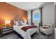 Comfortable bedroom with a colorful accent wall, plush bedding, and bright natural light from the window at 2585 Blue Sky Meadows Dr, Monroe, NC 28110
