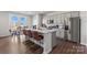 Modern kitchen featuring a large island with seating, granite countertops, and stainless steel appliances at 2585 Blue Sky Meadows Dr, Monroe, NC 28110