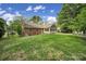 Exterior view of the home showing a spacious backyard, lush lawn, and a sunroom with plenty of natural light at 2626 Lilly Mill Rd, Charlotte, NC 28210