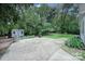 Spacious backyard featuring a patio, shed, picnic table, lush greenery, and ample space for outdoor activities at 2626 Lilly Mill Rd, Charlotte, NC 28210