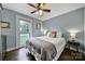 Comfortable bedroom features hardwood floors, a ceiling fan, and a bright window at 2626 Lilly Mill Rd, Charlotte, NC 28210