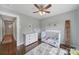 This cozy Bedroom features hardwood floors, a ceiling fan, and large windows for natural light at 2626 Lilly Mill Rd, Charlotte, NC 28210