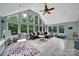 Bright sunroom featuring large windows, tile flooring, and vaulted ceiling with ceiling fan at 2626 Lilly Mill Rd, Charlotte, NC 28210