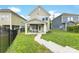 A well-maintained backyard features a covered patio and lush green lawn, bordered by a black metal fence at 2638 Double Oaks Rd, Charlotte, NC 28206
