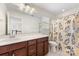 Bathroom featuring a cherry vanity, large mirror, and a shower with a decorative shower curtain at 2638 Double Oaks Rd, Charlotte, NC 28206